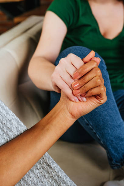 istock Young woman holding her friend's hand while talking about mental health problems 1368613635