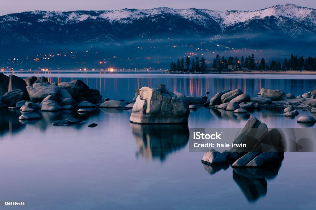 Night Sky Over Lake Tahoe A peaceful evening night view over the east shore of Lake Tahoe. In the mountains of the northern Sierra Nevada, Lake Tahoe is a popular tourist destination. Lake Tahoe Stock Photo