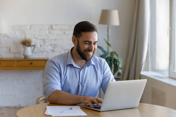 istock Smiling millennial businessman enjoying working on computer. 1368614993