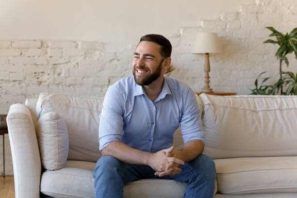 istock Happy dreamy millennial man looking in distance. 1368614998