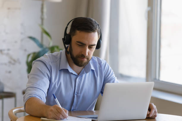 istock Focused young man studying distantly at home. 1368615025