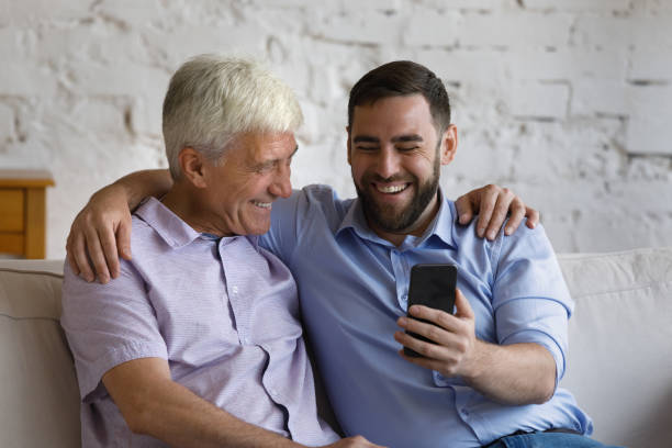 istock Happy bonding two male generations family using cellphone. 1368615063