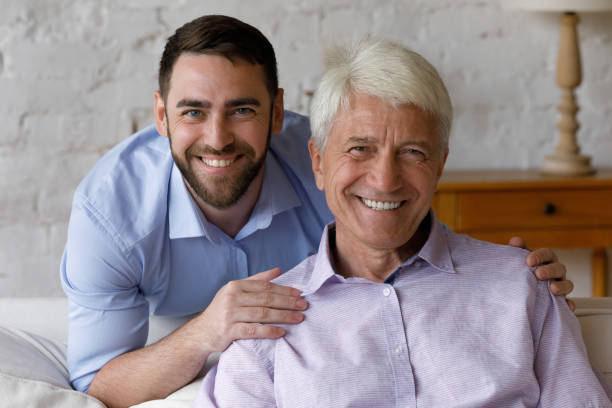 istock Head shot portrait young man cuddling old father. 1368615064