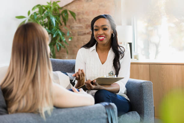 Therapist smiles and gestures while giving unrecognizable female client advice