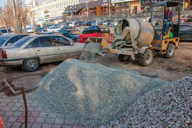 Dnipropetrovsk, Ukraine - 11.22.2021: Mobile concrete mixer at a construction site. Loading gravel for making concrete.