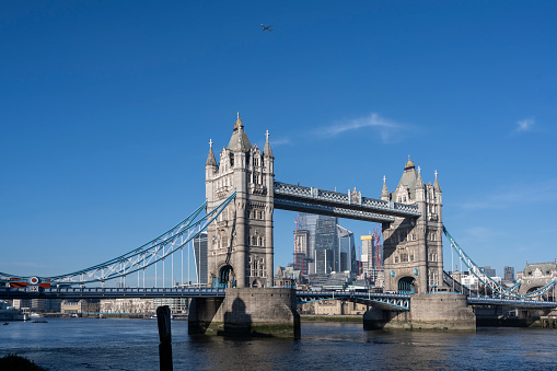 Tower Bridge and London's financial district behind it on a beautiful sunny day.