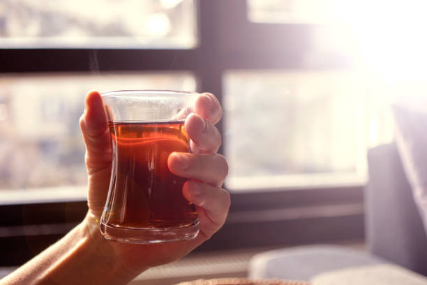 istock The lady drinking Turkish tea in a thin-waisted glass cup. black tea. 1368619898