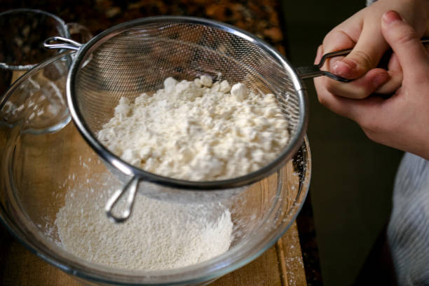 istock dough preparation, flour sifting. close-up. 1368619930