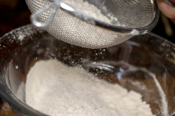 istock dough preparation, flour sifting. close-up. 1368619944
