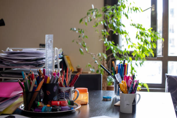 istock home desk, colored pencils, various papers are on the table. 1368621086