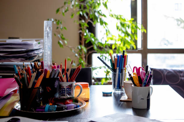 istock desk top. colored pencils on messy used table 1368623359