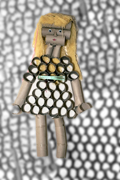 Recycled doll made with finished toilet paper roll. abstract background.