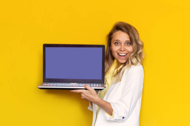 istock A young woman in a white jacket shows a very peri blank laptop screen for text or design 1368624097