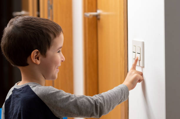 little boy switching a light off - startknop stockfoto's en -beelden