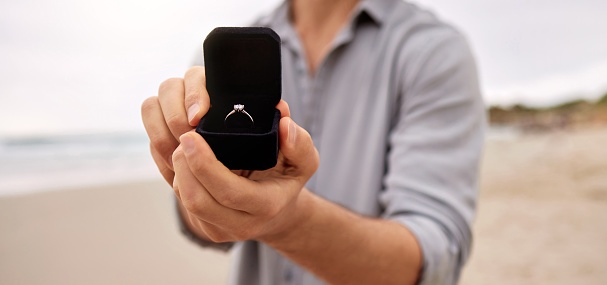 Foto de un hombre sosteniendo un joyero abierto con un anillo de compromiso photo
