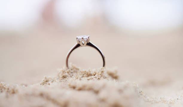 aufnahme eines verlobungsrings im sand - zoom ring stock-fotos und bilder