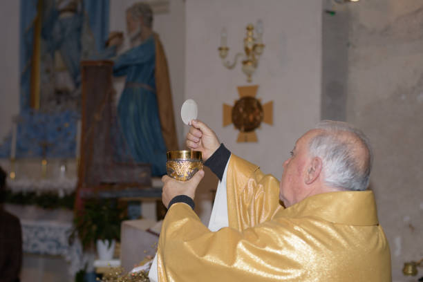 holy host in the hands of the priest on the altar during the celebration of the mass and empty space for text - mask religious celebration horizontal easter imagens e fotografias de stock