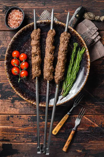 Grilled Shish kebab on skewers from minced lamb beef meat, Lula kebab. Wooden background. Top view.