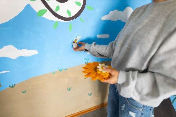 istock On the wall at nursery room, unrecognizable young woman adding flowers 1368632162