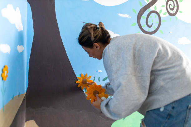 istock On the wall at nursery room, creative young woman adding flowers 1368632196