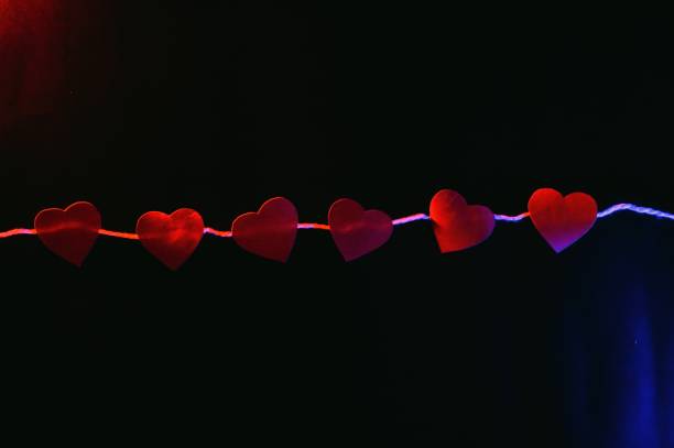 istock Paper hearts on black background 1368632543