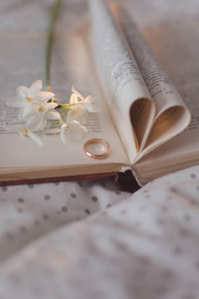 istock Wedding golden ring and open book with folded sheets in heart shape. Wedding concept, Valentines Day 1368635402