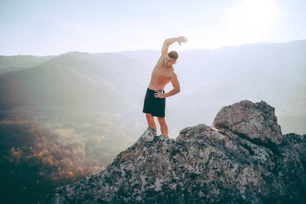 istock Young man stretching on the mountain 1368637943