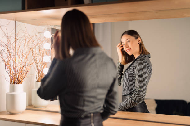 istock Lovely woman looking at her reflection in the mirror 1368641143