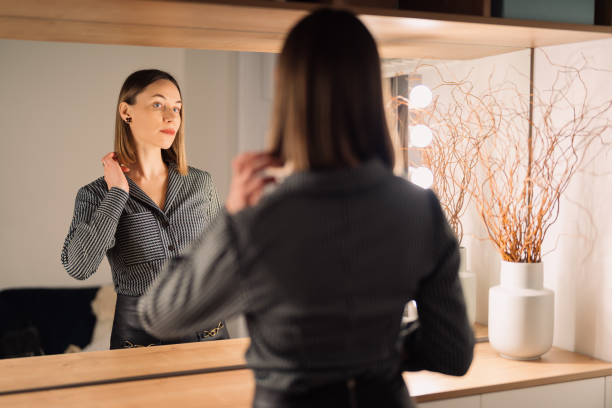 istock Lovely woman looking at her reflection in the mirror 1368641150