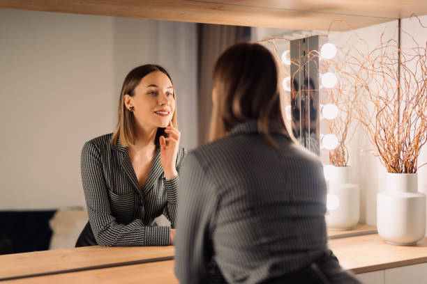 Lovely woman looking at her reflection in the mirror