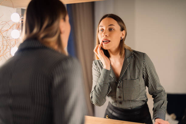 istock Lovely woman looking at her reflection in the mirror 1368641157