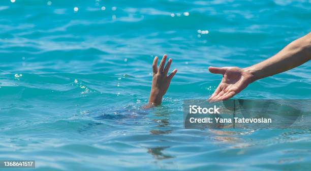 The Child Is Drowning In The Water The Hand Of Salvation Selective Focus Stock Photo - Download Image Now