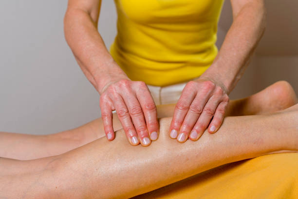 Man doing sports while kneading a man's sore leg and hands and feet on the floor 1