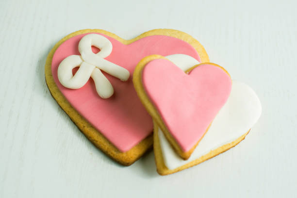 Handmade cookies with heart shape on white wood.