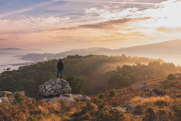 istock Beautiful landscape with a man on a rock 1368643354