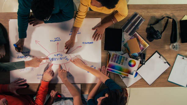 istock Business partners pointing to words ''business plan'' 1368644415