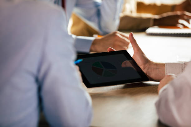 istock Businessman presenting a chart on a digital tablet to a coworker 1368645203