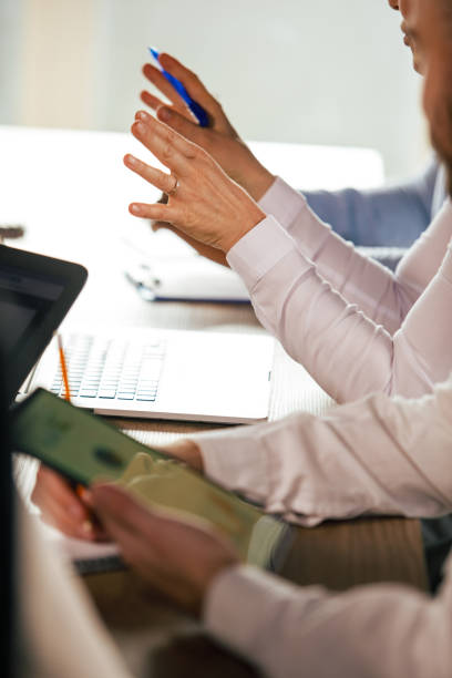 istock Businesswoman gesturing and explaining her solution to coworkers during a meeting 1368645217