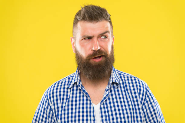 istock Sounds tricky. Man serious face raising eyebrow not confident. Have some doubts. Hipster bearded face not sure in something. Doubtful bearded man on yellow background close up. Doubtful expression 1368647299