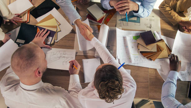 istock Architect and interior designer shaking hands after agreeing on idea during a meeting 1368650259