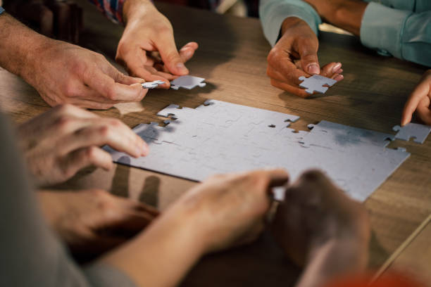 istock Team of people cooperating on solving a jigsaw puzzle 1368650571