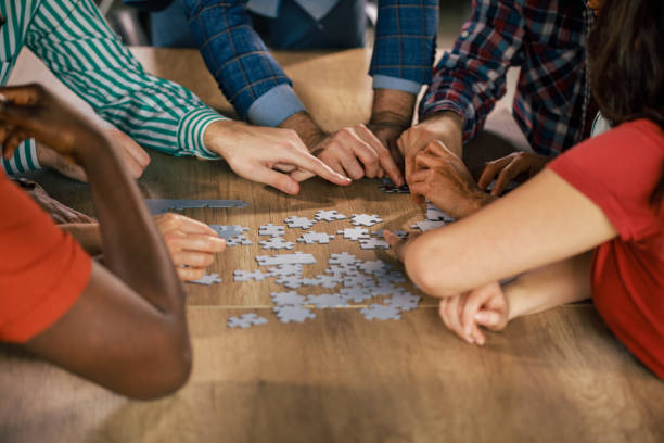 istock Friends hanging out and assembling a jigsaw puzzle 1368650581