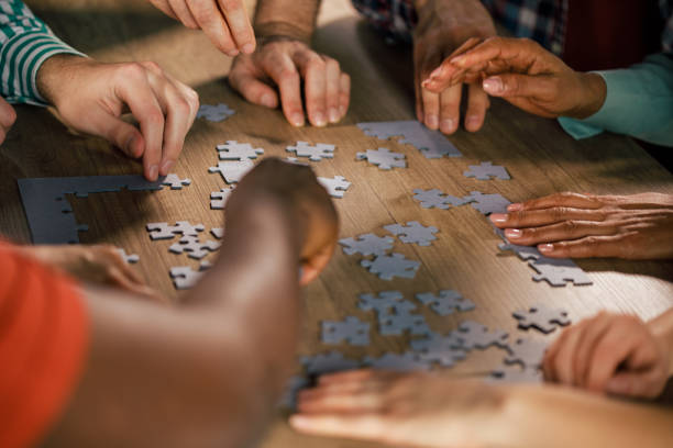istock Close up shot of unrecognizable group of friends assembling a puzzle 1368650587