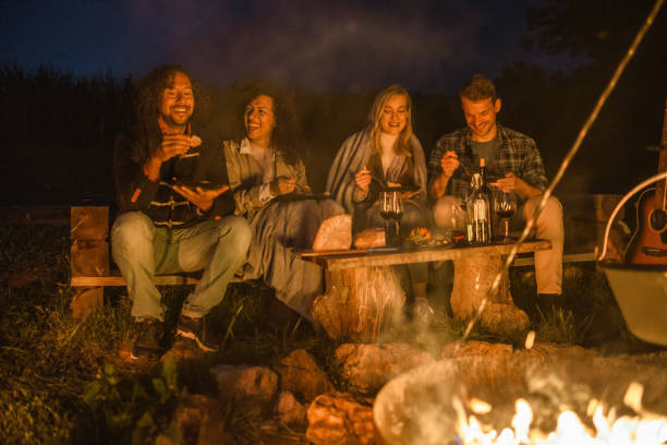 自然の中で一緒にキャンプ混合レースの友人 - friendship camping night campfire ストックフォトと画像
