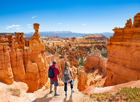 People relaxing on top of the mountain. Couple hiking on summer vacation. Famous Thor's Hammer hoodoo. Bryce Canyon National Park, Utah, USA