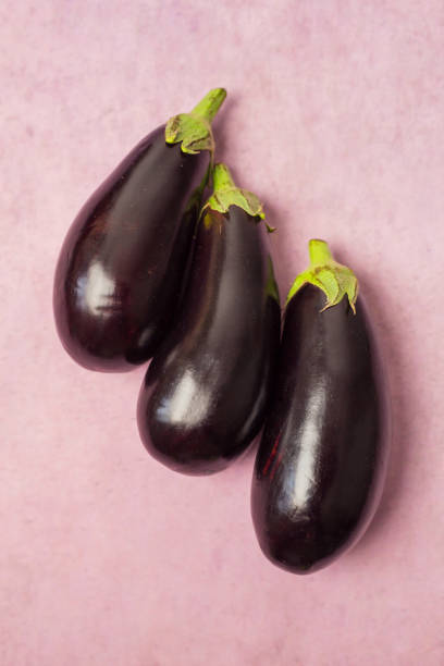 istock Closeup of eggplants on a pink background 1368658865