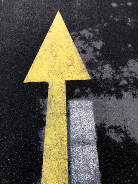 istock Close-up diagonal direction line painted in yellow on black asphalt 1368661742