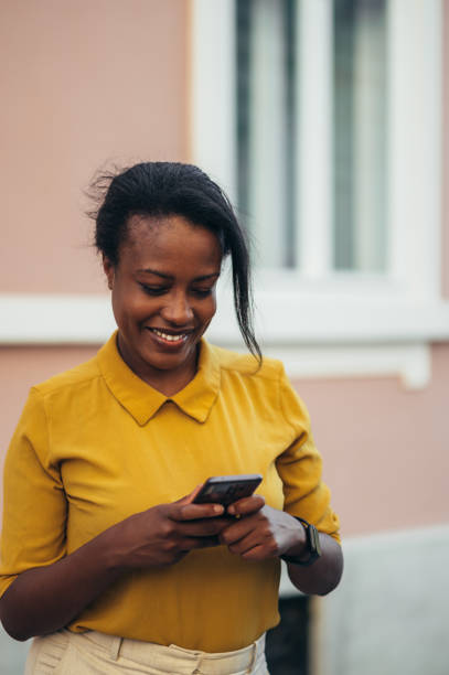 istock African american woman using a smartphone while walking in the city 1368664411