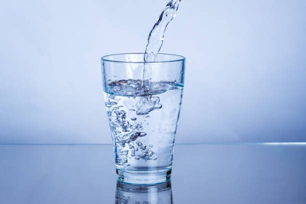 istock Pouring drink mineral water into a glass 1368665357
