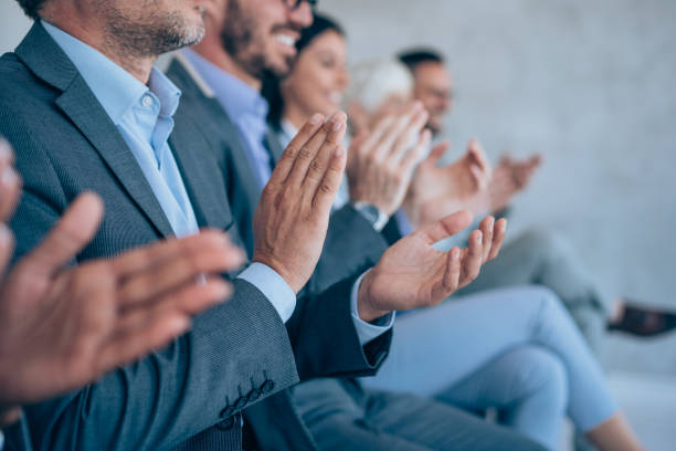 empresarios aplaudiendo durante un seminario en la sala de conferencias. - applauding fotografías e imágenes de stock